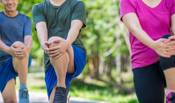 Father mother and adult son exercise in the park