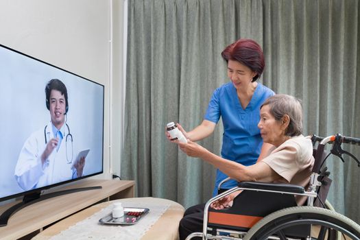 Elderly woman sit at home having online consultation with doctor on tablet computer.