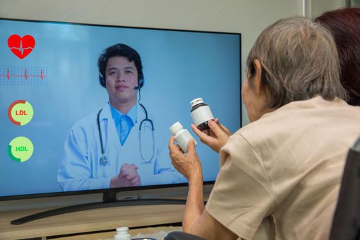 Elderly woman sit at home having online consultation with doctor on tablet computer.