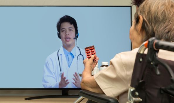 Elderly woman sit at home having online consultation with doctor on tablet computer.