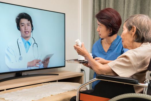 Elderly woman sit at home having online consultation with doctor on tablet computer.