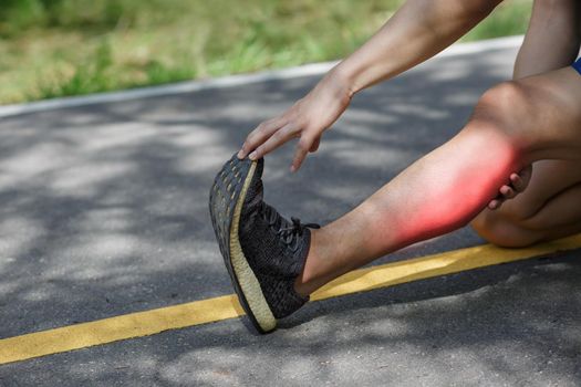 Male middle aged having a cramp while jogging. Stop and massage calf