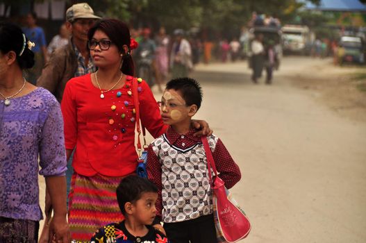 BAGAN, MYANMAR - NOVEMBER 18, 2015 Adult ethnic woman with children in big family walking on street, Myanmar. Ethnic family walking on road