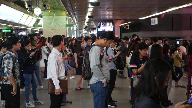 BANGKOK, THAILAND - 18 DECEMBER, 2018: Passenger at BTS Skytrain station in Bangkok Thailand, everybody looking down at smartphone while waiting for the BTS skytrain.