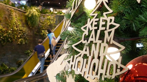 BANGKOK, THAILAND - 18 DECEMBER, 2018: EmQuartier asian shopping mall interior. People on escalators of trade centre rush to shopping, modern contemporary plaza. Christmas decoration. new year tree