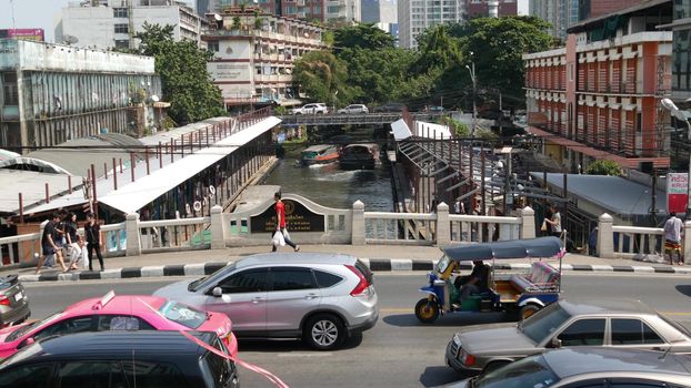 BANGKOK, THAILAND - 18 DECEMBER, 2018 Pratunam pier, express boat public transport stop in center of city. Saen Saep canal. Busy traffic on Ratchadamri road