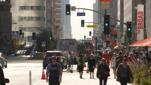 LOS ANGELES, CALIFORNIA, USA - 30 OCT 2019: People walking in metropolis, pedestrians on walkway in urban downtown. Citizens on street in financial district. City dwellers in LA among skyscrapers.