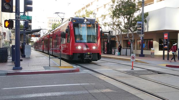 SAN DIEGO, CALIFORNIA USA - 4 JAN 2020: MTS Trolley on tramway, ecological public passenger transportation. Electric tram line station in Gaslamp Quarter. City transport stop on crossroad of downtown.