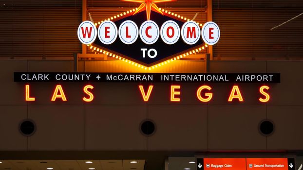 LAS VEGAS, NEVADA USA - 9 MAR 2020: Welcome to fabulous Sin City illuminated retro neon sign inside McCarran airport. Iconic greeting vintage styled signboard glowing. Gambling casino resort symbol.