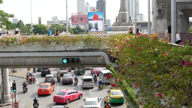 BANGKOK, THAILAND - 10 JULY, 2019: Rush hour traffic near Victory Monumet in Krungthep capital. Famous asian landmark and travel destination. Downtown modern city life. People and passengers of bts