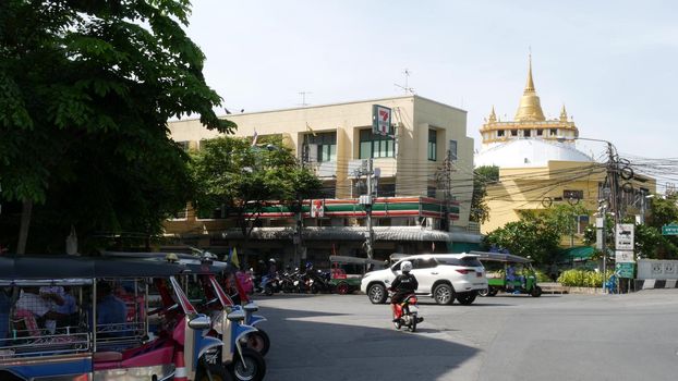 BANGKOK, THAILAND - 11 JULY, 2019: Rush hour traffic near Wat Saket in capital. Famous asian landmark and travel destination. Ancient religious monastery and public transport on the road in downtown