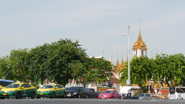 BANGKOK, THAILAND - 11 JULY, 2019: Rush hour traffic near Wat Saket in capital. Famous asian landmark and travel destination. Ancient religious monastery and public transport on the road in downtown