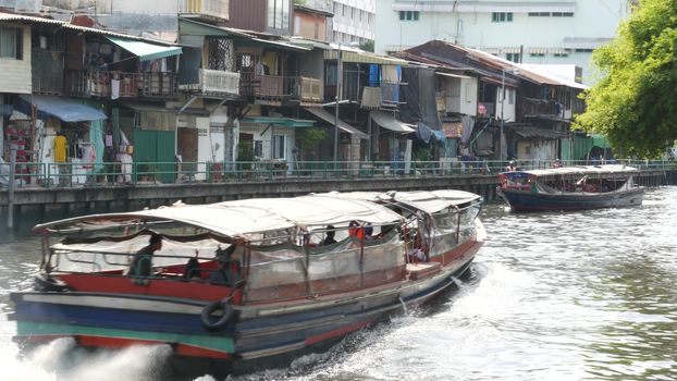 BANGKOK, THAILAND, 11 JULY 2019: Canal as classic typical water way for public passengers transportation. Street city life on khlong. Local people use boat as traditional transport during traffic jam.