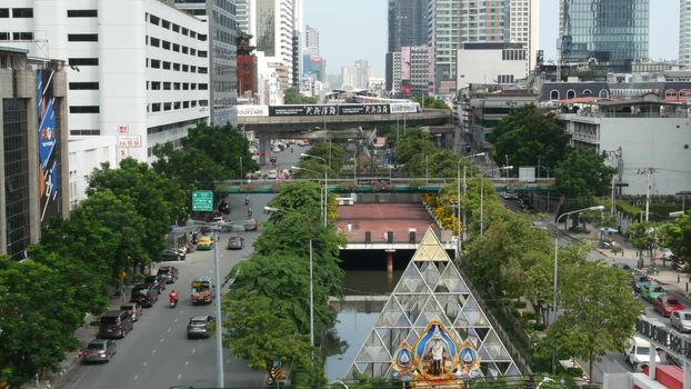 BANGKOK, THAILAND - 13 JULY, 2019: Traffic on modern city street. Contemporary train riding on railroad bridge over road with cars in center of capital