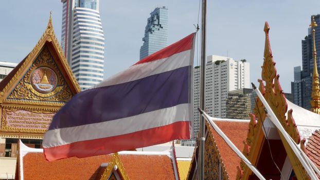 BANGKOK, THAILAND - 13 JULY, 2019: Conceptual contrast of oriental old traditional ancient temple and modern new futuristic Mahanakhon skyscraper. Classic buddhist wat compared to urban cityscape