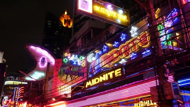 BANGKOK, THAILAND,13 JULY 2019: Vivid neon signs glowing on Soi Cowboy street. Nightlife in erotic Red light district. Illuminated bar and adult go-go show club. Night life tourist entertainment.