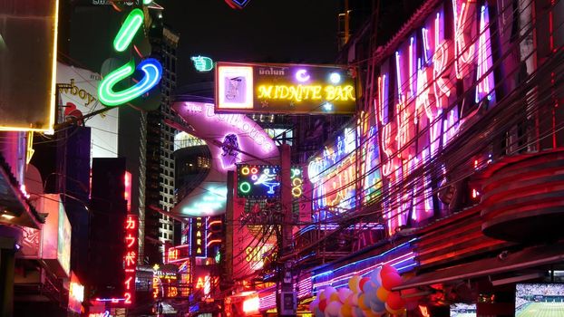 BANGKOK, THAILAND,13 JULY 2019: Vivid neon signs glowing on Soi Cowboy street. Nightlife in erotic Red light district. Illuminated bar and adult go-go show club. Night life tourist entertainment.