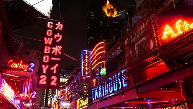 BANGKOK, THAILAND,13 JULY 2019: Vivid neon signs glowing on Soi Cowboy street. Nightlife in erotic Red light district. Illuminated bar and adult go-go show club. Night life tourist entertainment.