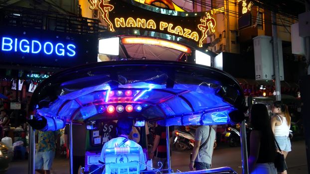 BANGKOK, THAILAND,13 JULY 2019 Vivid neon signs glowing, Nana Plaza street. Nightlife in erotic Red light district soi. Illuminated bar and adult go-go show club. Night life tourist entertainment