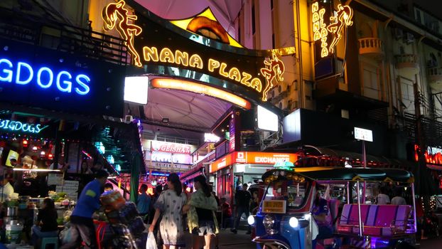 BANGKOK, THAILAND,13 JULY 2019 Vivid neon signs glowing, Nana Plaza street. Nightlife in erotic Red light district soi. Illuminated bar and adult go-go show club. Night life tourist entertainment