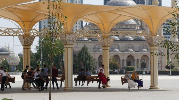 GROZNY, THE CHECHEN REPUBLIC OF ICHKERIA, CAUCASUS, RUSSIA, 6 SEPTEMBER 2019 Day of Civil Concord and Unity, The Heart of Chechnya. Happy young people, joyful muslim men and women having fun on swing