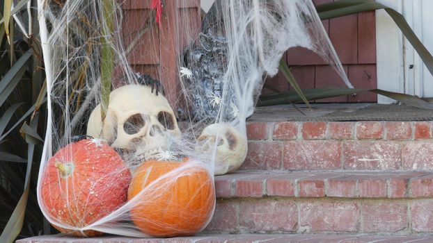 LOS ANGELES, CALIFORNIA, USA - 29 OCT 2019: Scary festival decorations of a house, Happy Halloween holiday. Doorway stairs with jack-o-lantern pumpkin. Traditional party decor. American culture.