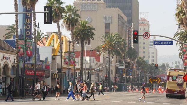 LOS ANGELES, CALIFORNIA, USA - 7 NOV 2019: Walk of fame promenade, Hollywood boulevard in LA city. Pedastrians walking on sidewalk of street. Entertainment and cinema industry iconic tourist landmark.