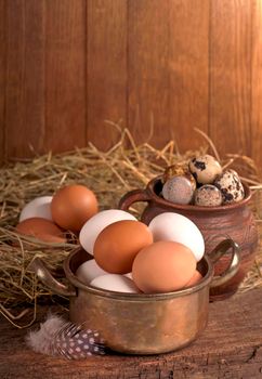 Brown eggs in wooden basket. Broken egg with yolk in background.