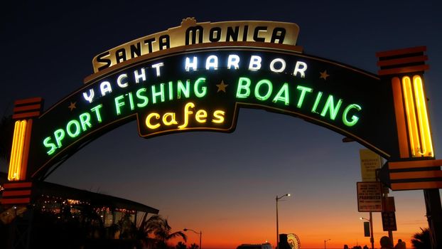 SANTA MONICA, LOS ANGELES CA USA - 19 DEC 2019: Summertime iconic vintage symbol. Classic illuminated retro sign on pier. California summertime aesthetic. Glowing lettering on old-fashioned signboard.