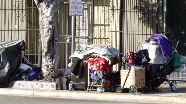 SAN DIEGO, CALIFORNIA USA - 4 JAN 2020: Stuff of homeless street people on walkway, truck on roadside. Begging problem in downtown of city near Los Angeles. Jobless beggars live on pavements.