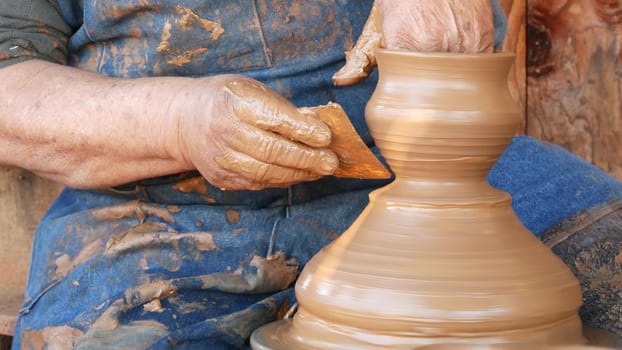 SAN DIEGO, CALIFORNIA USA - 5 JAN 2020: Potter working in mexican Oldtown, raw clay on pottery wheel. Man's hands, ceramist in process of modeling handcrafted clayware. Craftsman creating ceramic.