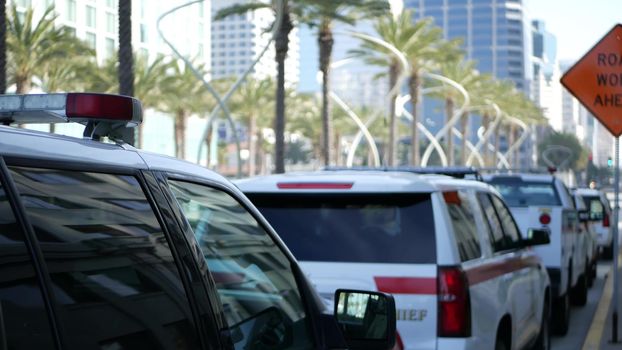 SAN DIEGO, CALIFORNIA USA - 15 JAN 2020: Fire department trucks and Sheriff's car with emergency sirens parked on Broadway. Firefighters vehicles in downtown. Fire engine for rescue and public safety.
