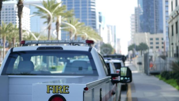 SAN DIEGO, CALIFORNIA USA - 15 JAN 2020: Fire department trucks and Sheriff's car with emergency sirens parked on Broadway. Firefighters vehicles in downtown. Fire engine for rescue and public safety.