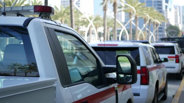 SAN DIEGO, CALIFORNIA USA - 15 JAN 2020: Fire department trucks and Sheriff's car with emergency sirens parked on Broadway. Firefighters vehicles in downtown. Fire engine for rescue and public safety.