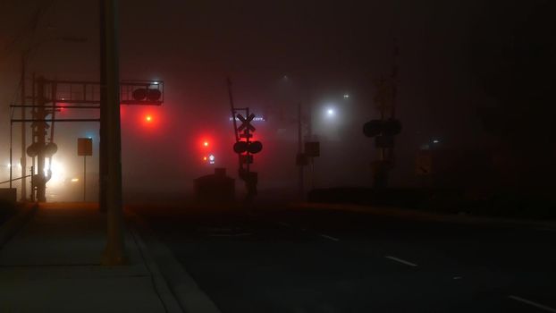 VISTA, CALIFORNIA USA - 24 JAN 2020: Marine layer, dense fog on driveway crossroad at night. June gloom, misty nebulous bad weather. Dangerous low visibility on road intersection. Car traffic safety.