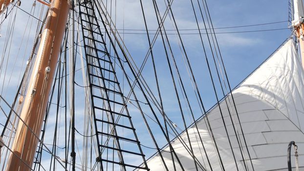 SAN DIEGO, CALIFORNIA USA - 30 JAN 2020: Retro sailing ship Star of India, full rigged wooden masts of Maritime Museum. Historic British frigate with white sails and ropes. Old large barque sailboat.