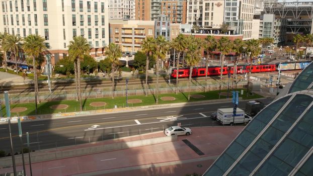 SAN DIEGO, CALIFORNIA USA - 30 JAN 2020: MTS red trolley and metropolis urban skyline, highrise skyscrapers in city downtown. From above aerial view, various buildings in Gaslamp Quarter and tram.