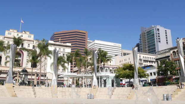SAN DIEGO, CALIFORNIA USA - 13 FEB 2020: Metropolis urban downtown. Fountain in Horton Plaza Park, various highrise buildings and people in Gaslamp Quarter. Citizens walking in financial district.