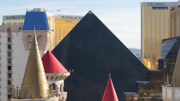 LAS VEGAS, NEVADA USA - 4 MAR 2020: Excalibur castle and Luxor pyramid casino uncommon aerial view. Plane flying from McCarran airport. Mandalay Bay and Delano hotel in american gambling sin city.