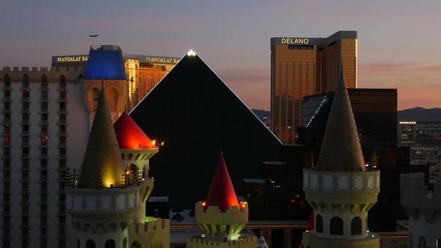 LAS VEGAS, NEVADA USA - 4 MAR 2020: Excalibur castle and Luxor pyramid casino uncommon aerial view. Plane flying from McCarran airport. Mandalay Bay and Delano hotel in american gambling sin city.