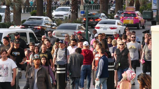 LAS VEGAS, NEVADA USA - 5 MAR 2020: People on pedestrian walkway. Multicultural men and women walking on city promenade. Crowd of citizens on sidewalk. Diversity of multiracial faces in metropolis.