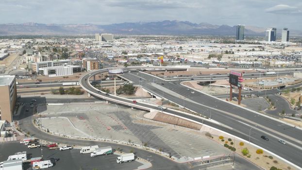 LAS VEGAS, NEVADA USA - 7 MAR 2020: Sin city in Mojave desert from above. Traffic highway in valley with arid climate. Aerial view of road in tourist metropolis. Gambling and betting area with casino.