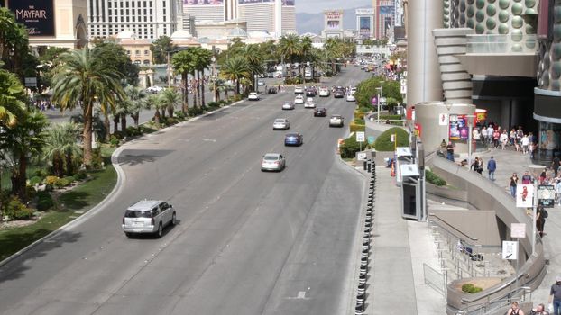 LAS VEGAS, NEVADA USA - 7 MAR 2020: The Strip boulevard with luxury casino and hotels in gambling sin city. Car traffic on road to Fremont street in tourist money playing resort. People walking.