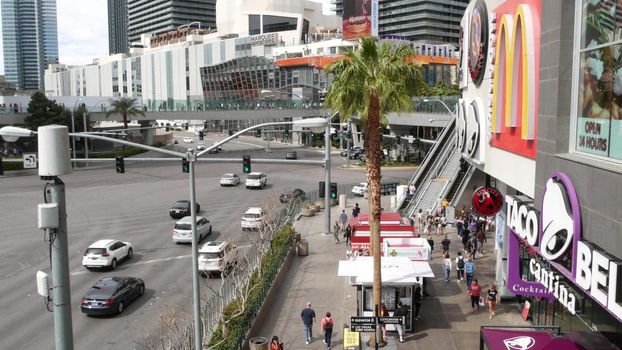 LAS VEGAS, NEVADA USA - 7 MAR 2020: The Strip boulevard with luxury casino and hotels in gambling sin city. Car traffic on road to Fremont street in tourist money playing resort. People and McDonalds.