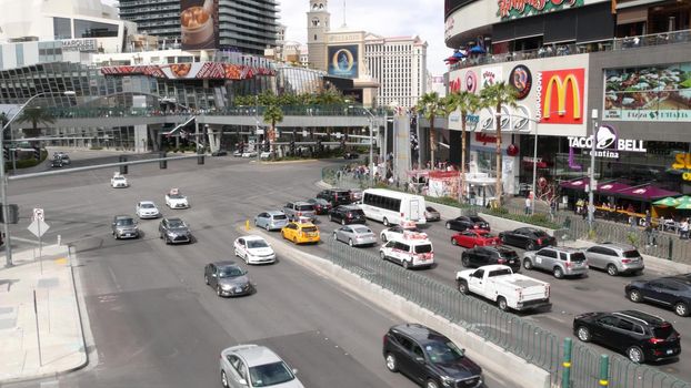 LAS VEGAS, NEVADA USA - 7 MAR 2020: The Strip boulevard with luxury casino and hotels in gambling sin city. Car traffic on road to Fremont street in tourist money playing resort. People and McDonalds.