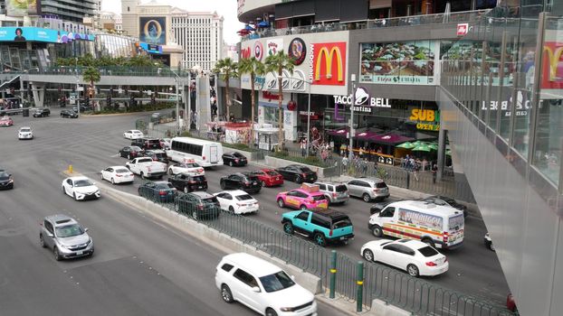 LAS VEGAS, NEVADA USA - 7 MAR 2020: The Strip boulevard with luxury casino and hotels in gambling sin city. Car traffic on road to Fremont street in tourist money playing resort. People and McDonalds.