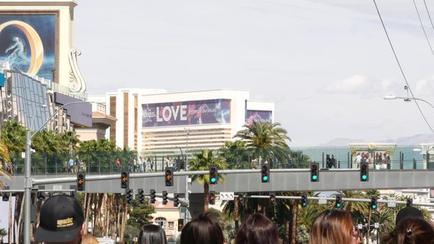 LAS VEGAS, NEVADA USA - 7 MAR 2020: People on pedestrian skyway. Multicultural men and women walk on skybridge. Crowd of citizens on pedway. Diversity of multiracial tourists on skywalk in metropolis.