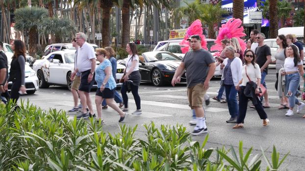 LAS VEGAS, NEVADA USA - 7 MAR 2020: People on pedestrian walkway. Multicultural men and women walking on city promenade. Crowd of citizens on sidewalk. Diversity of multiracial faces in metropolis.