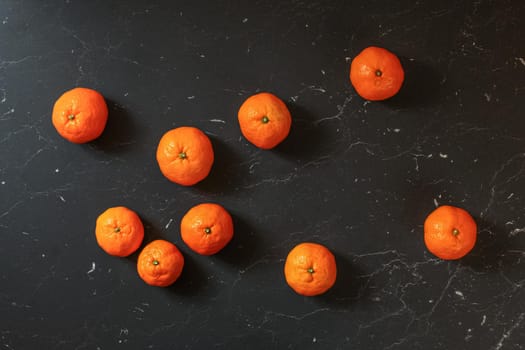 Top down view, mandarines tangerines on black marble board.