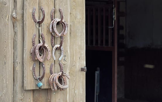 Old worn horseshoes displayed on wall of stables.